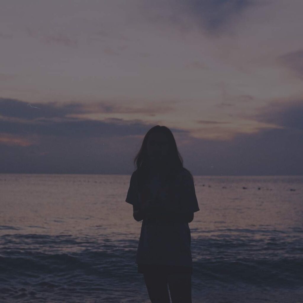 Woman staring into the ocean.