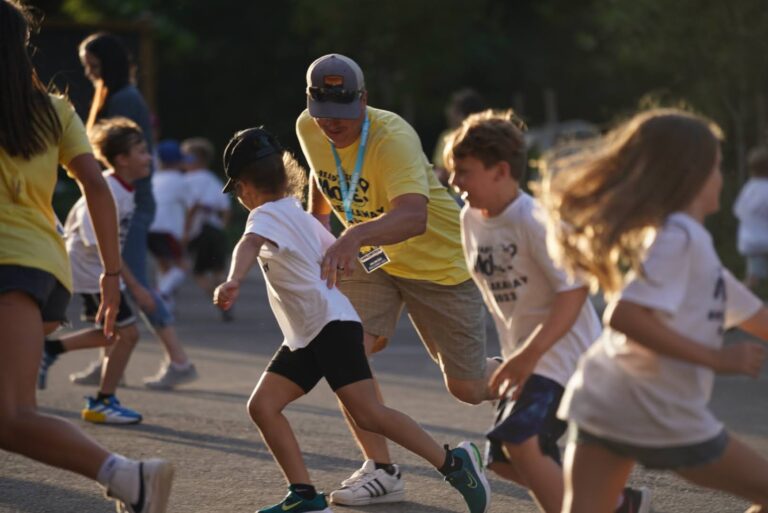 Adults and kids play active game outside at VBS.