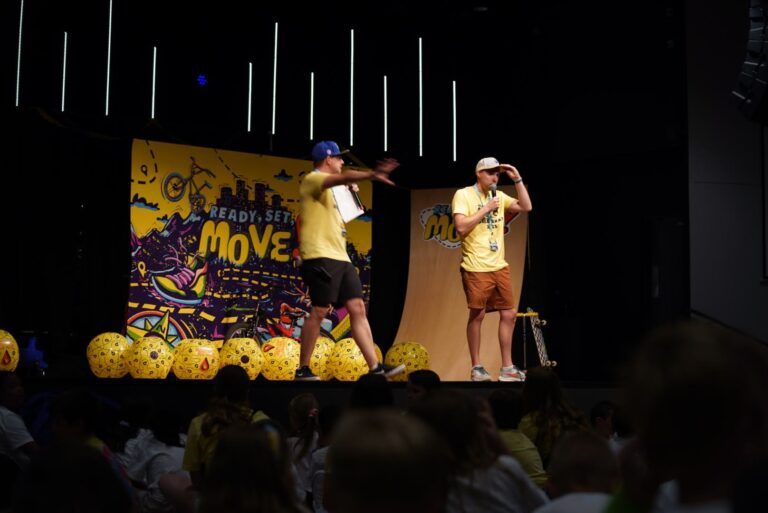 Two adult leaders doing comedic routine on stage.